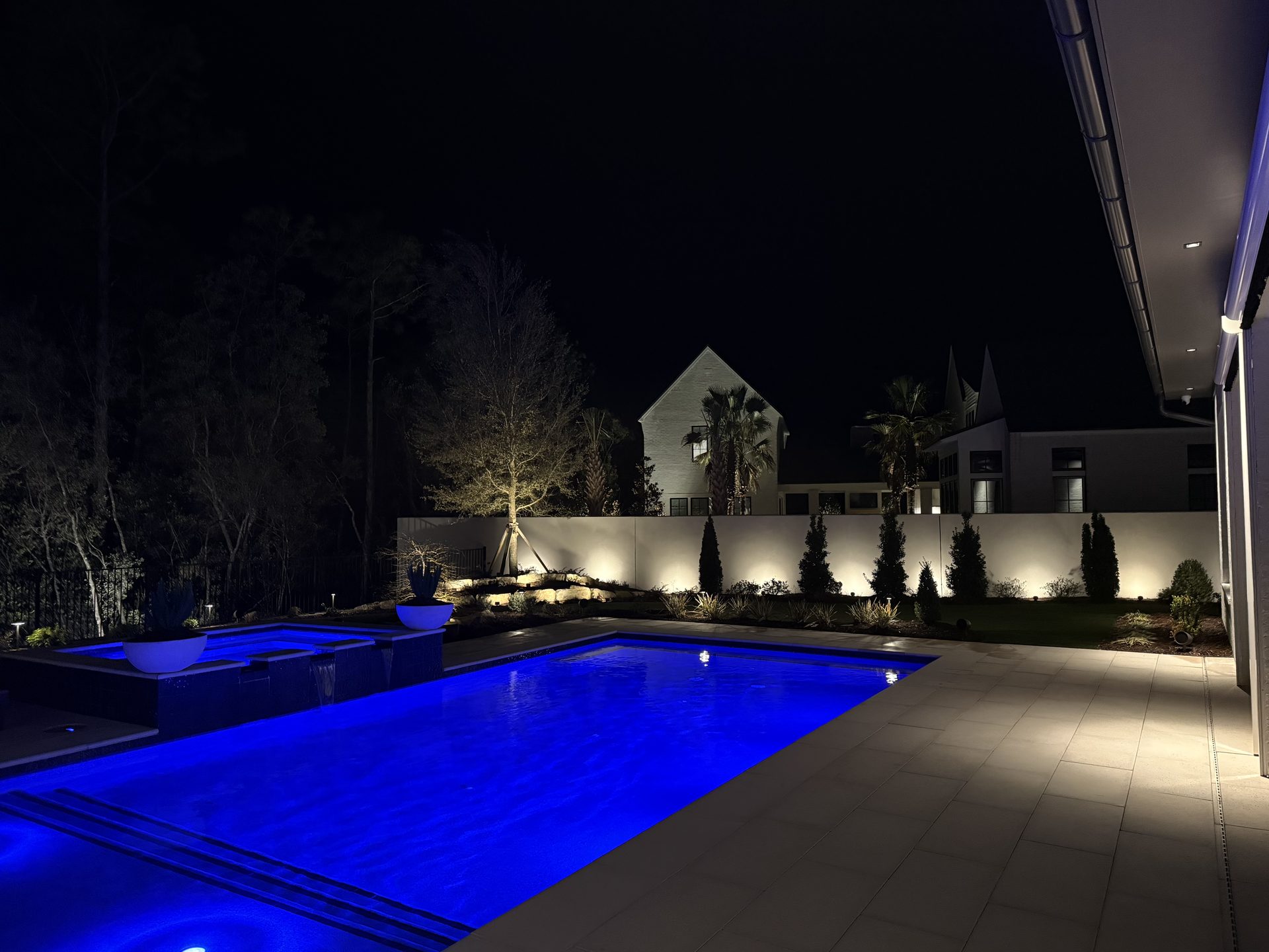 Pool and spa with blue lighting and landscape uplights