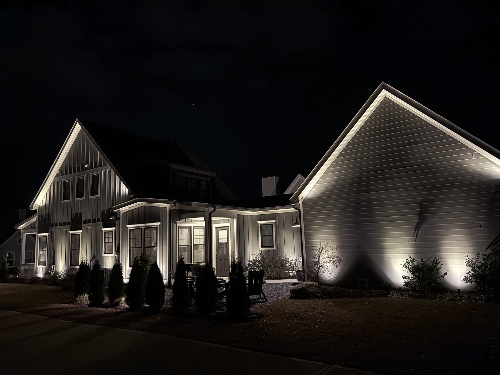 White farmhouse exterior with soffit and accent lighting